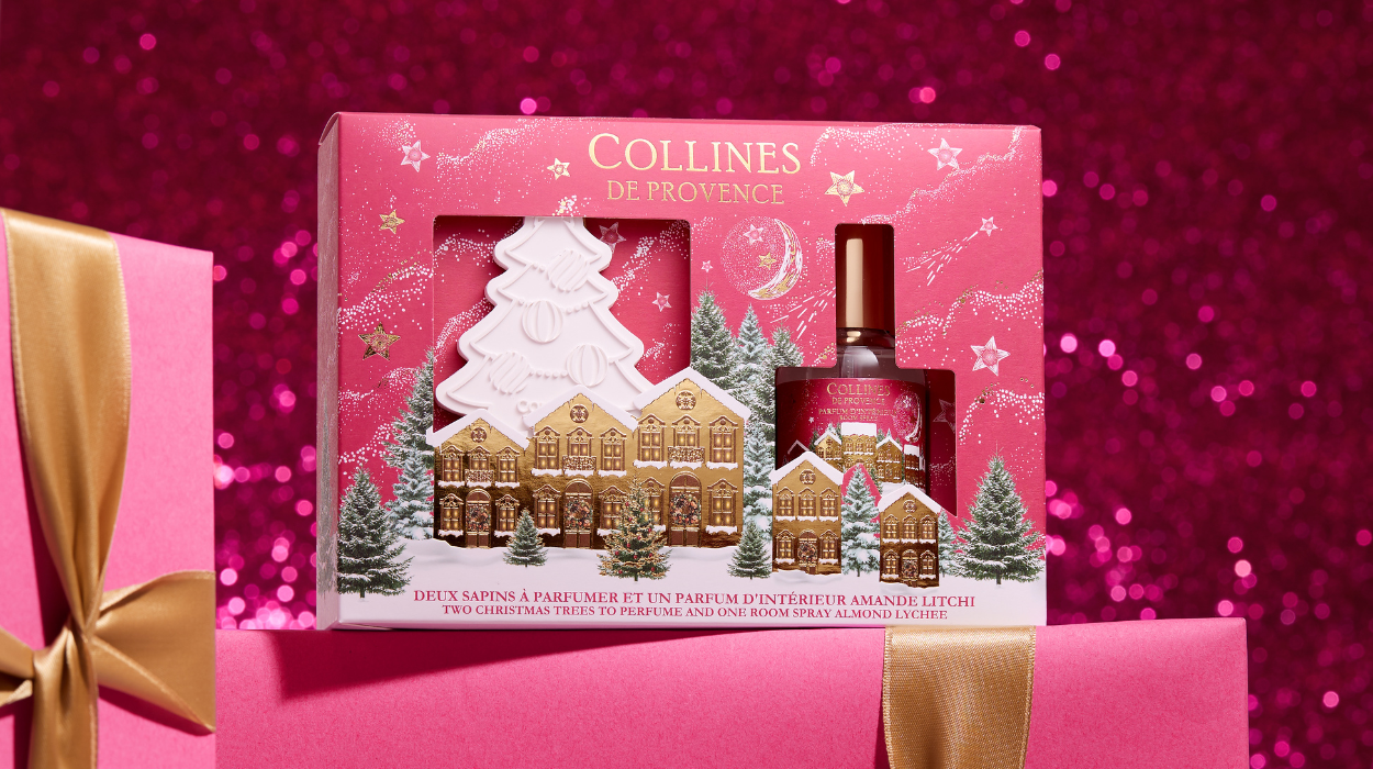 coffret cadeau rose comprenant un parfum d'ambiance et une c&eacute;ramique en forme de sapin dispos&eacute; sur des cadeaux 