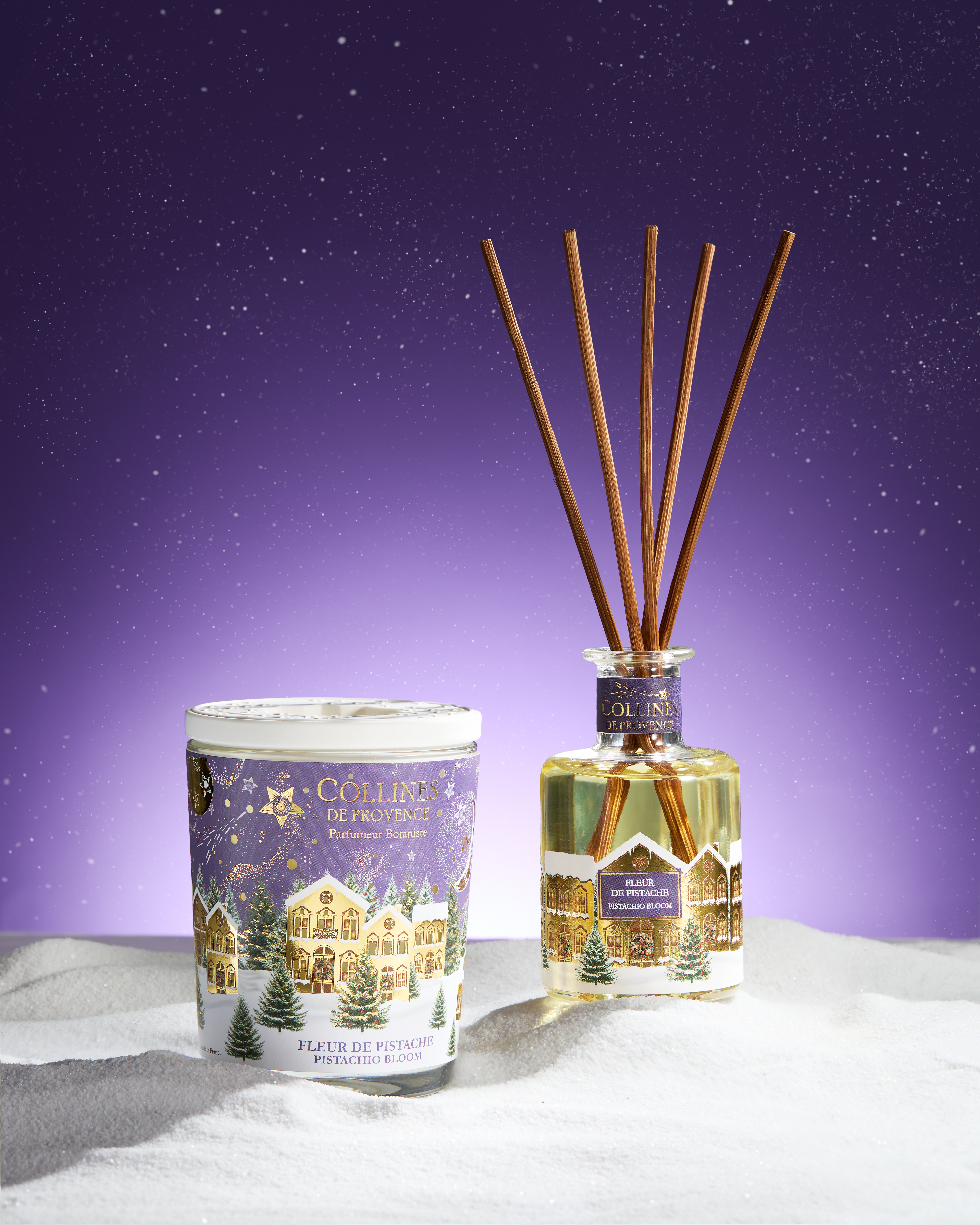 Photo d'une tabl&eacute;e de No&euml;l avec des bougies de diff&eacute;rentes couleurs dispos&eacute;es sur une table festive. Sapin de no&euml;l  en arri&egrave;re plan.